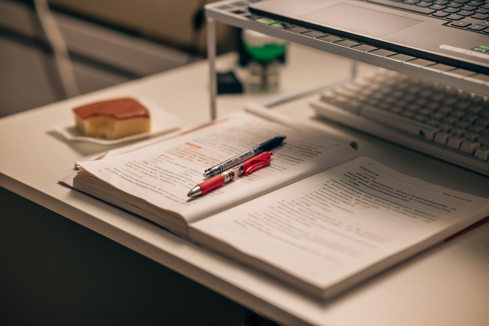 Open textbook and laptop on a study desk