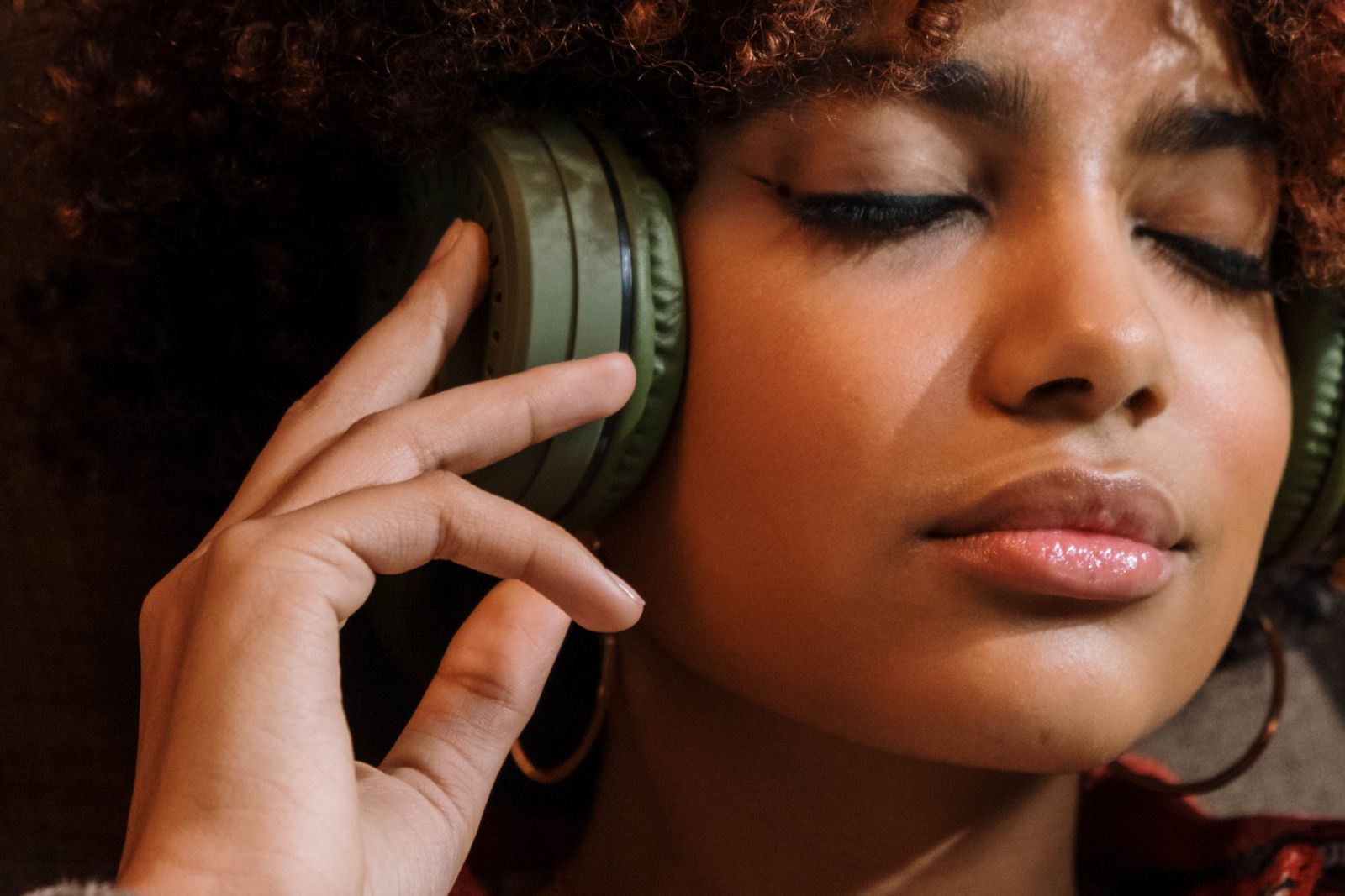 A woman listening to calm ambient sound with headphones and her eyes closed